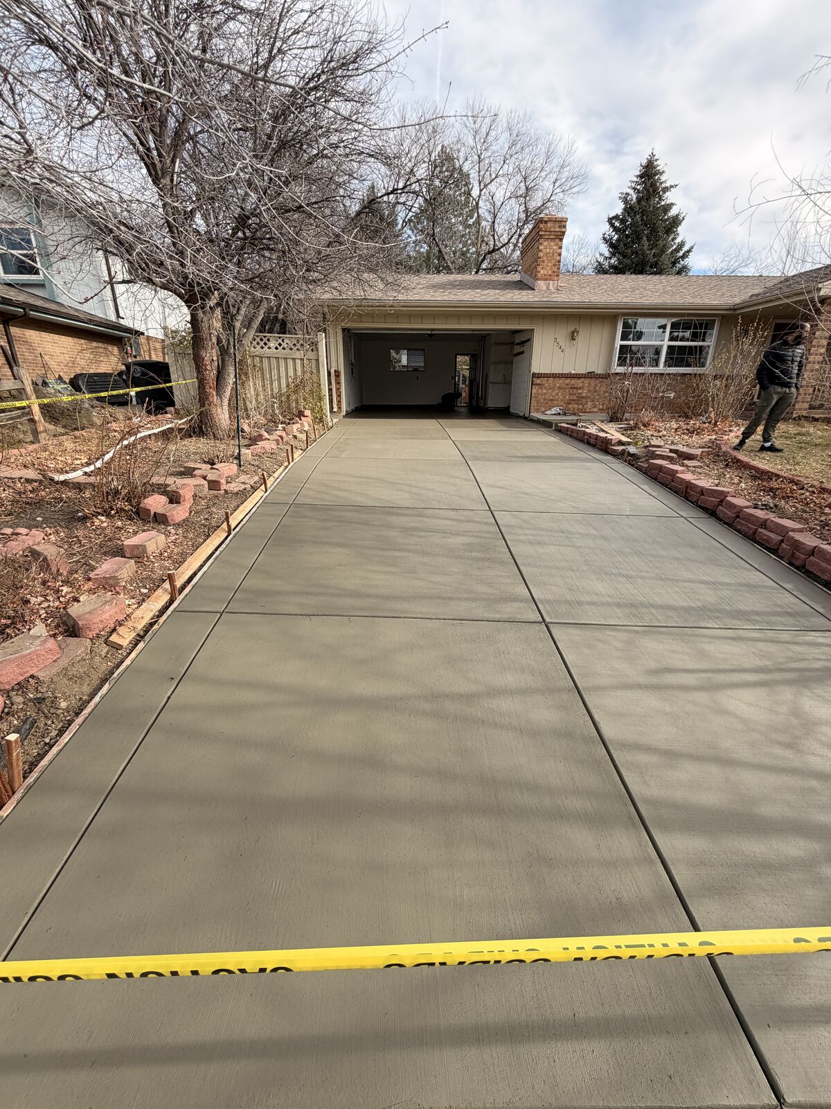 Freshly poured concrete driveway in front of a two car garage