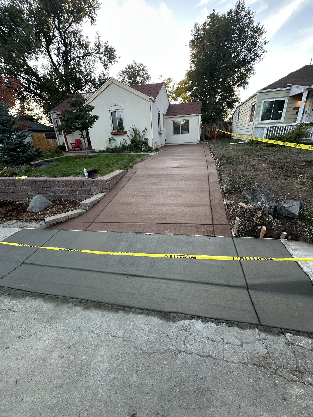 Stained concrete driveway leading to a stucco home