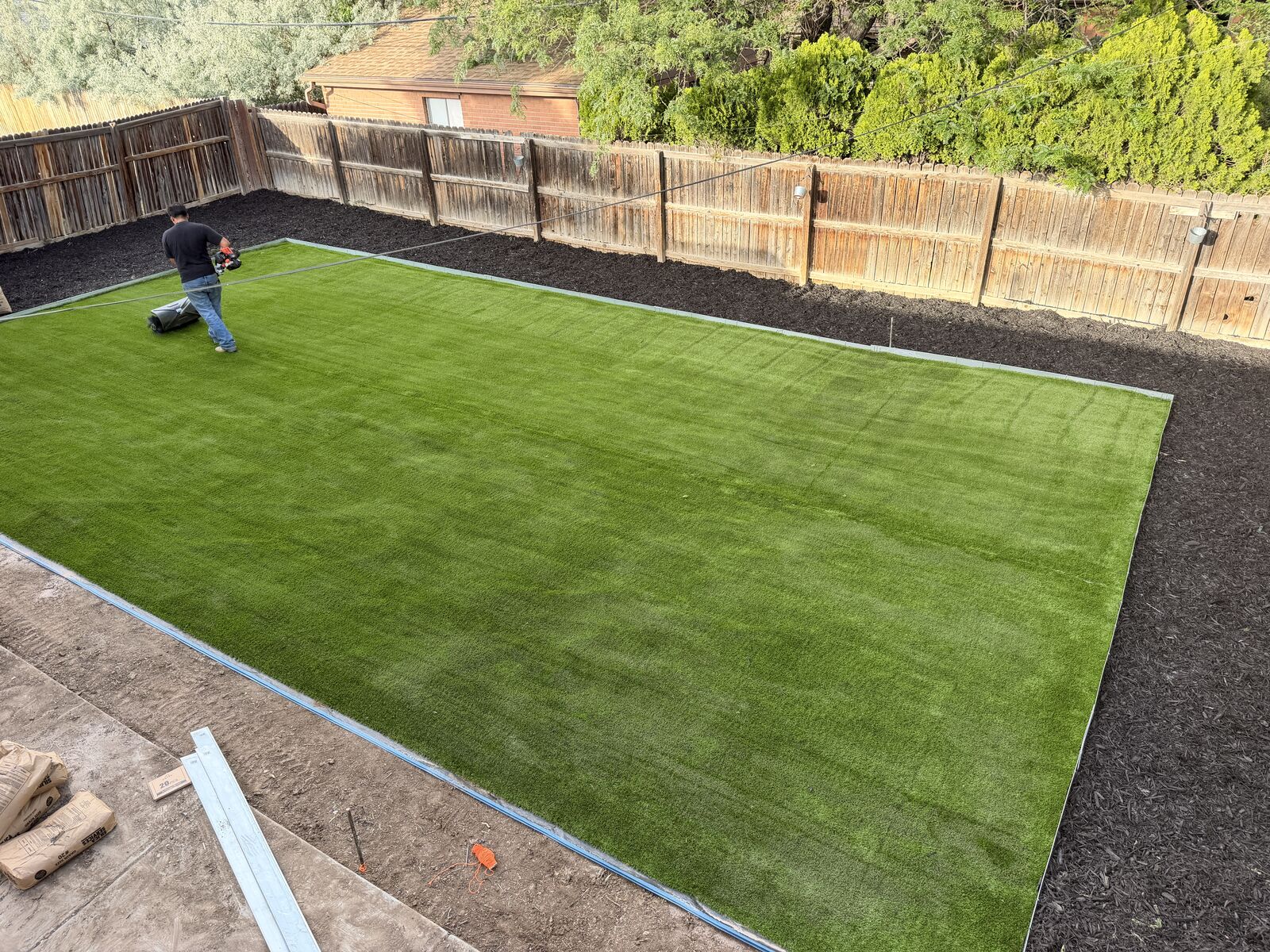 Artificial turf installation in progress in a backyard
