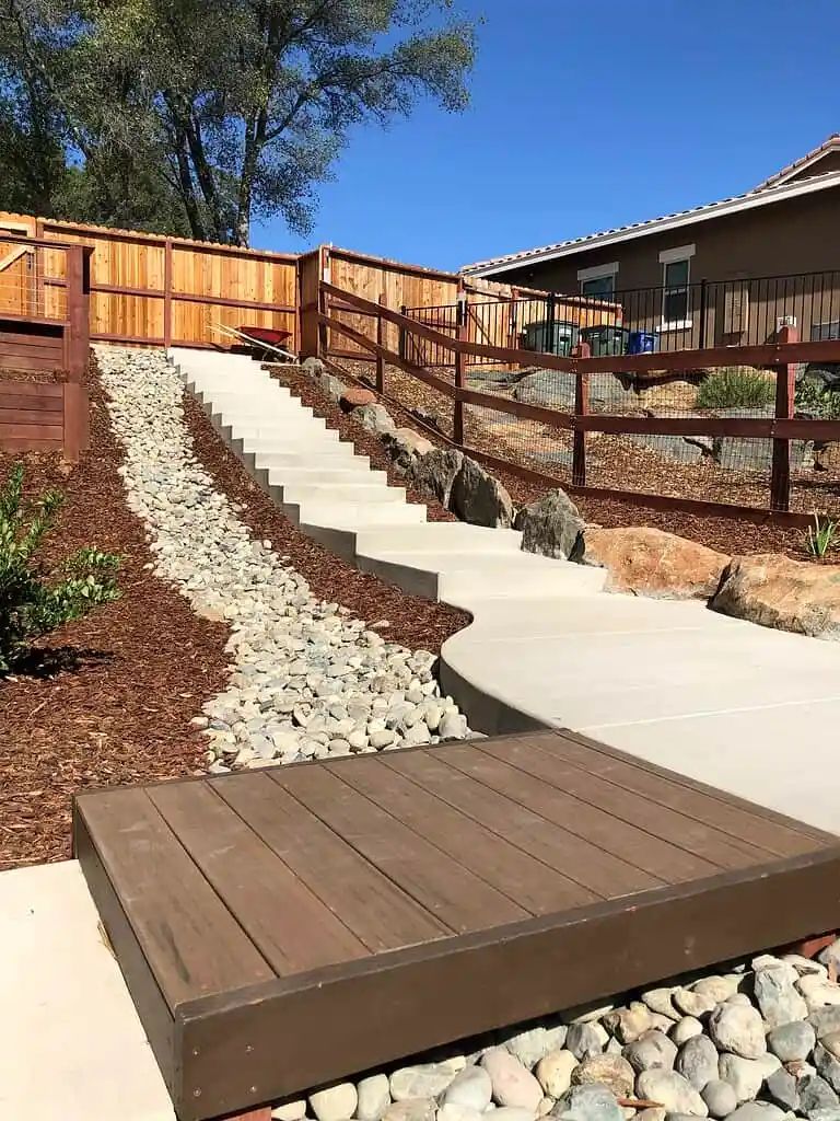 Curved concrete steps and walkway with rock drainage channel