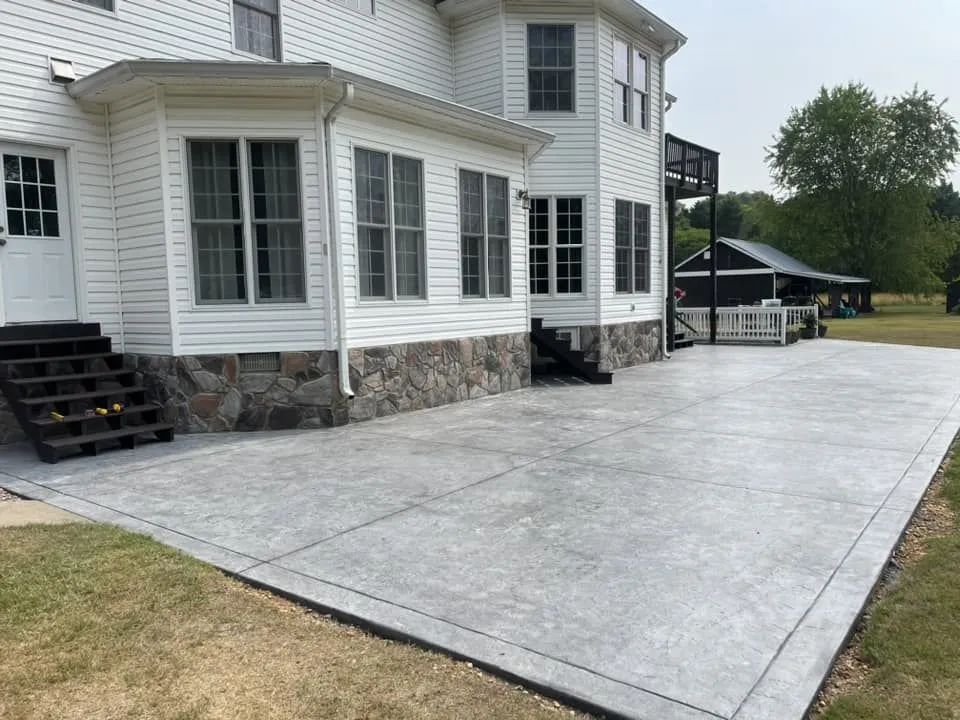 Stamped concrete patio with natural stone skirting